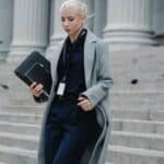 Serious businesswoman hurrying with documents from courthouse