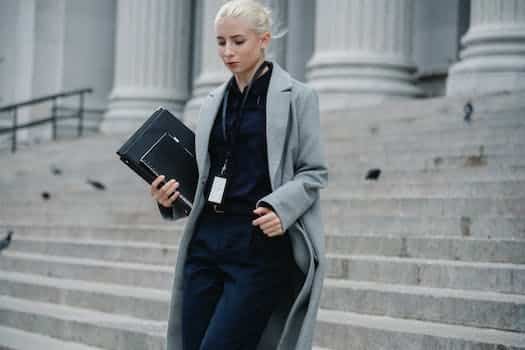 Serious businesswoman hurrying with documents from courthouse