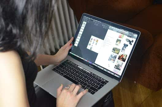 Side view of unrecognizable female with dark hair looking at screen and surfing contemporary netbook while working online at home