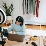 Focused woman working at desk on laptop in studio