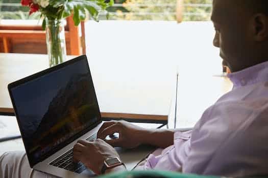 Black man with smart watch browsing laptop
