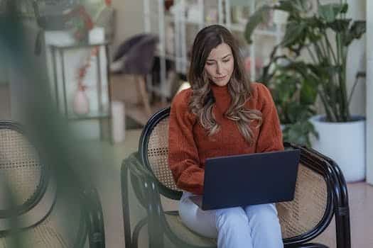Serious female entrepreneur doing work on laptop