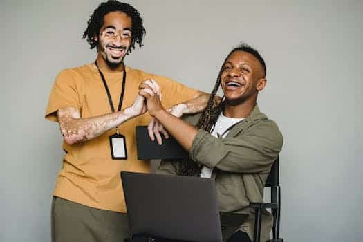 Smiling black coworkers holding hands in studio